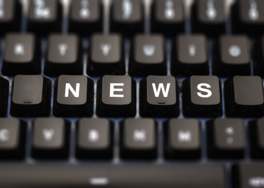 Online news, journalism concept. News word written on keypad. Black keys with white letters message for press articles on pc keyboard. Blur buttons background.
