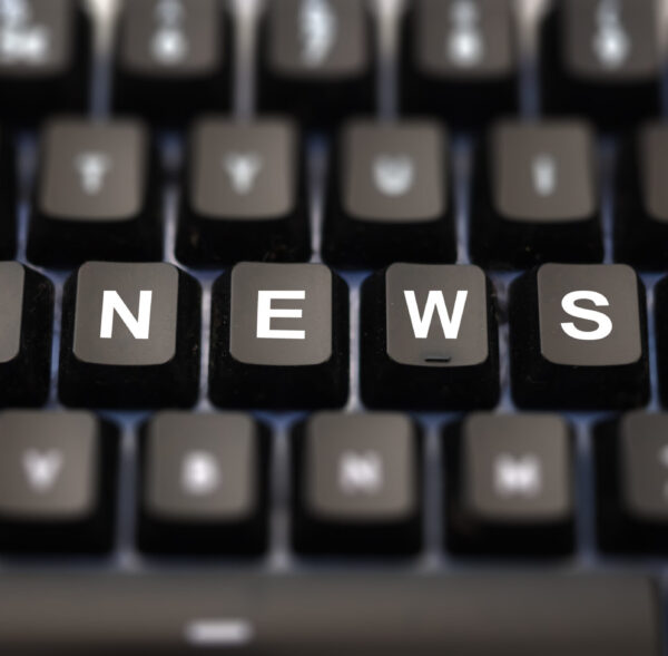 Online news, journalism concept. News word written on keypad. Black keys with white letters message for press articles on pc keyboard. Blur buttons background.