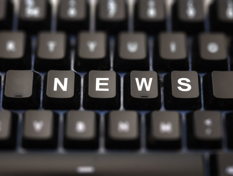 Online news, journalism concept. News word written on keypad. Black keys with white letters message for press articles on pc keyboard. Blur buttons background.